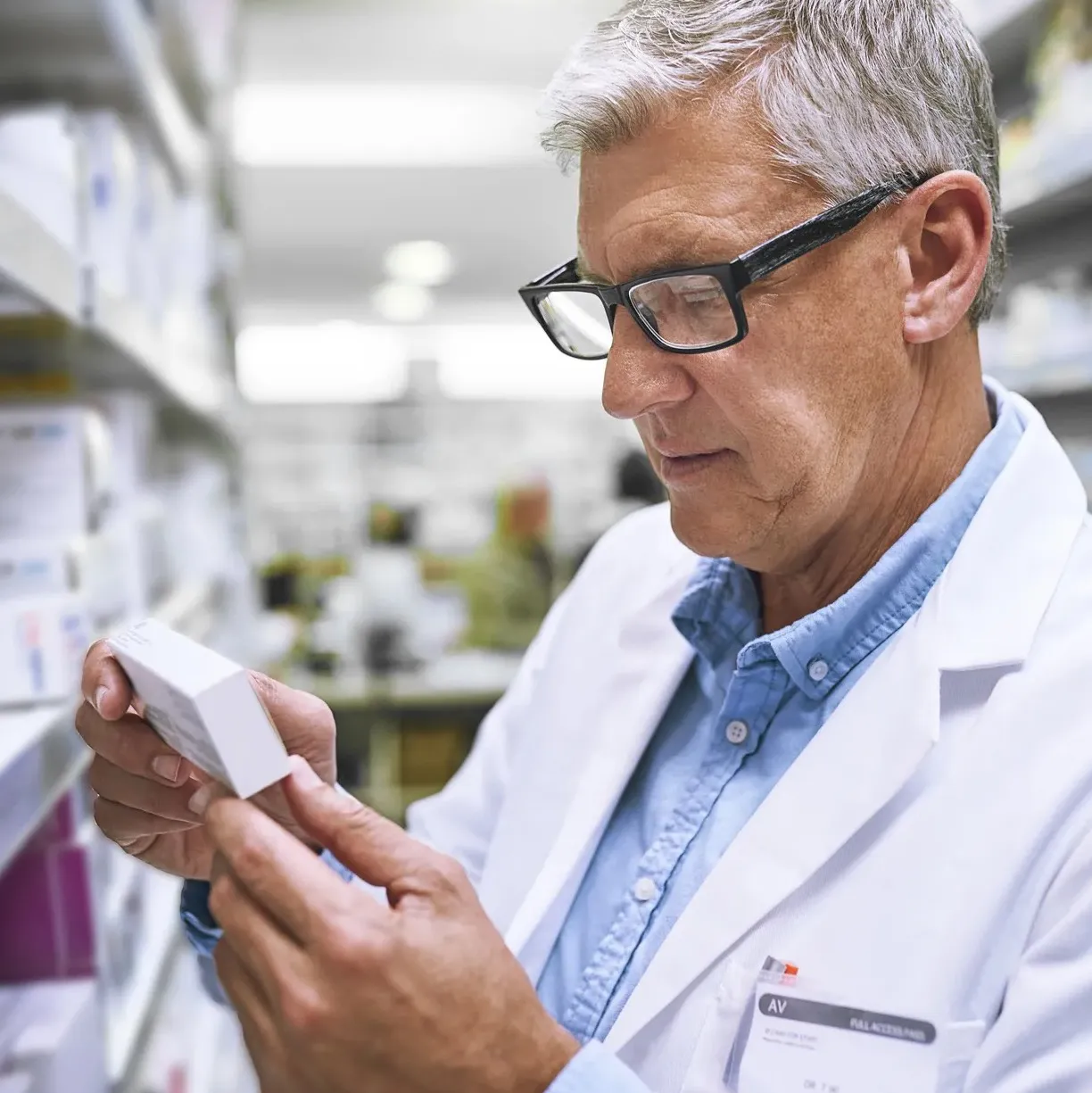 Dispensing doctor examining a medicine box