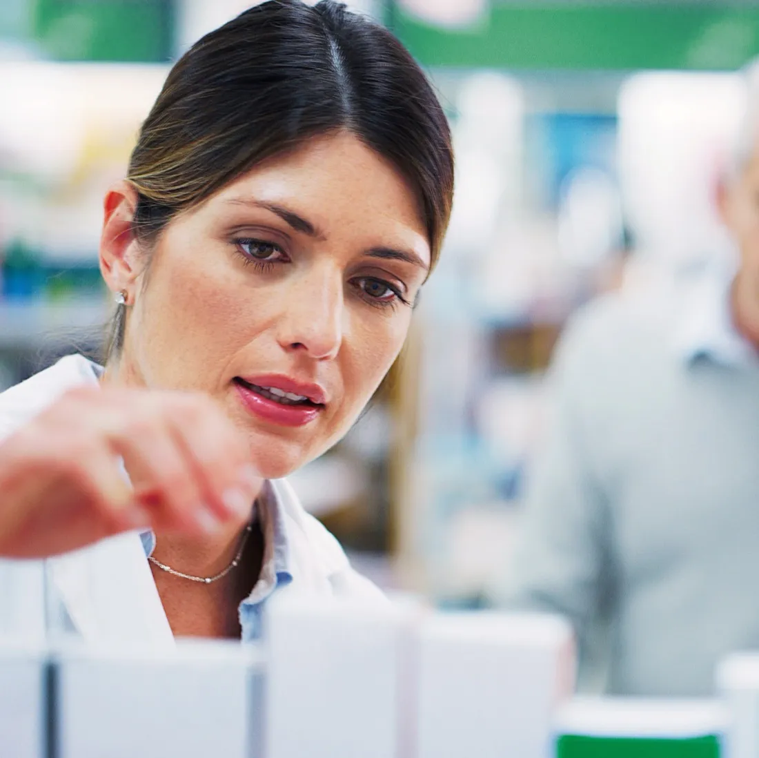 Pharmacist selecting medicines from a shelf